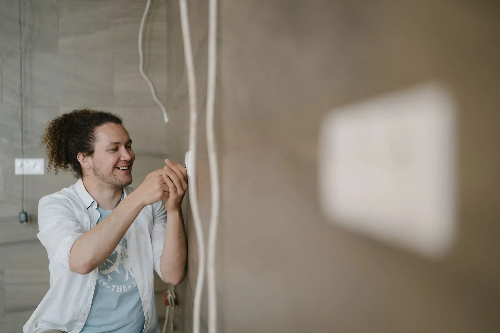 An electrician fitting a new power point on a wall