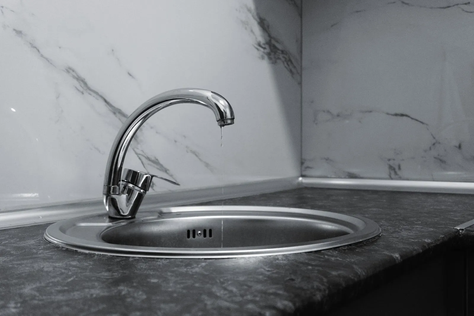 New kitchen mixer tap installed over a stone benchtop