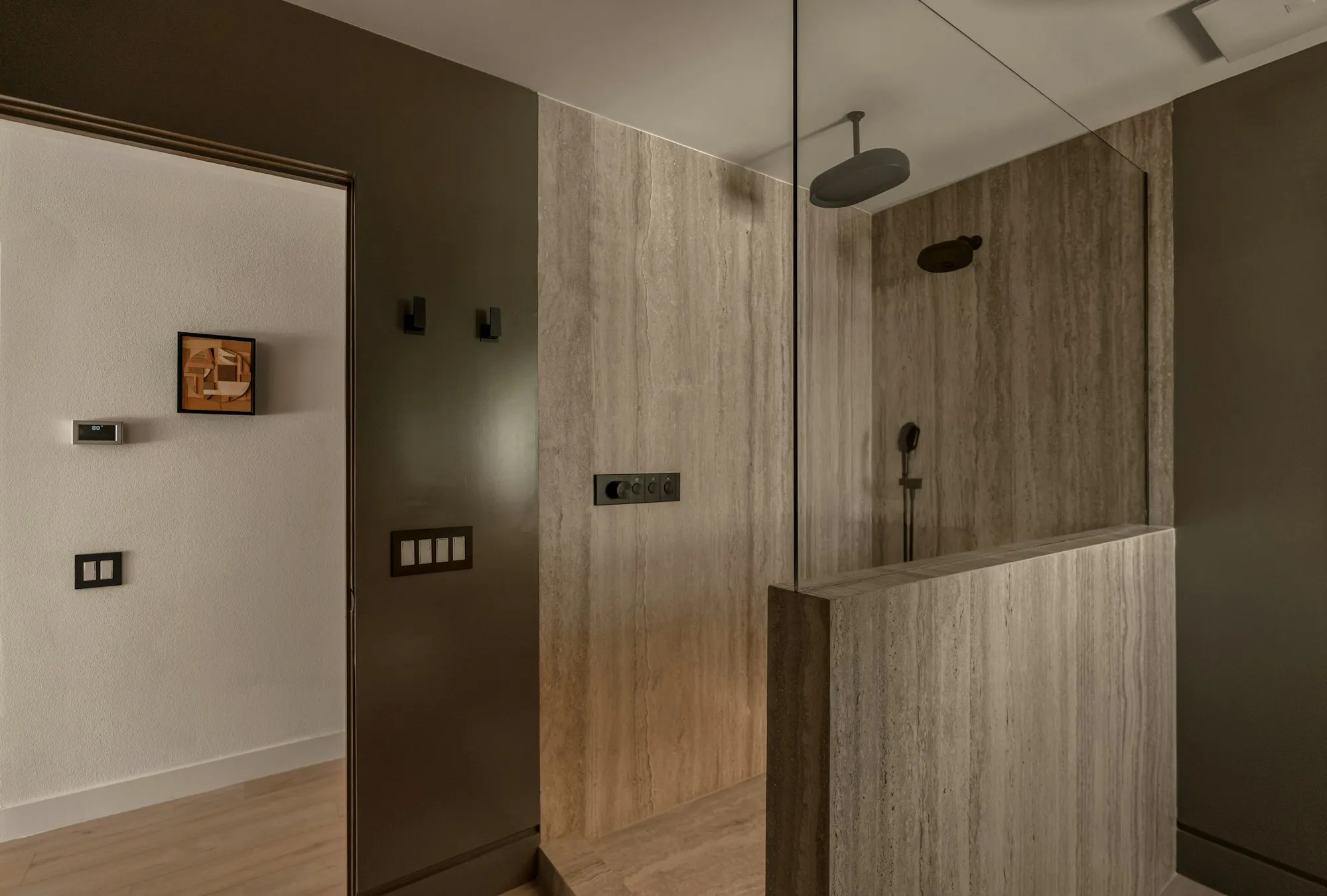 A frameless walk in shower with stone and timber finishes