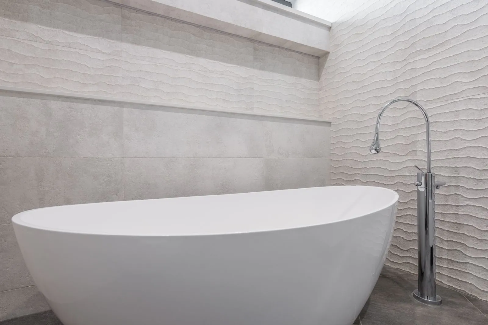 A freestanding bath beneath a picture window in a Nedlands main bathroom